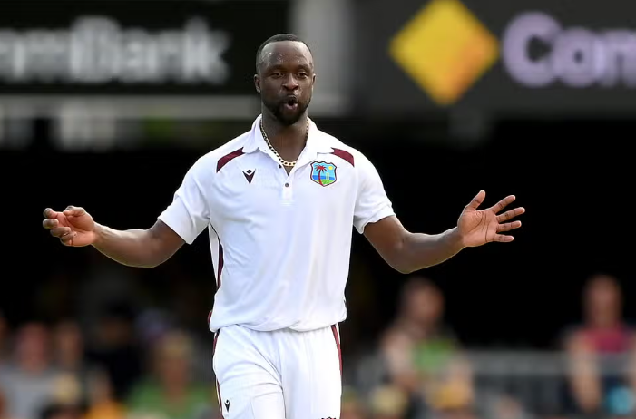 West Indies pacer Kemar Roach bowling during a cricket match, wearing the team's uniform.